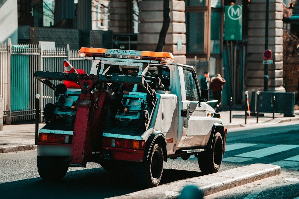 Wrecker tow truck with boom and wheel-lift on a city street